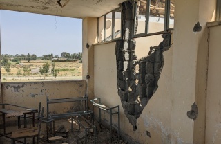 Image looking out of a building which has been left in ruin after the recent conflict.